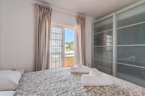 a bedroom with a large bed and a large window at Casa do Rei - Charneca in Charneca
