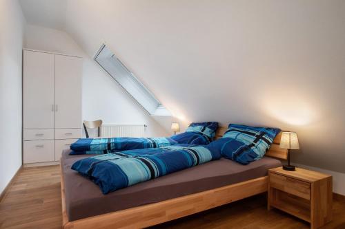 a bedroom with a large bed with blue pillows at Obsthof Mainberger in Kressbronn am Bodensee
