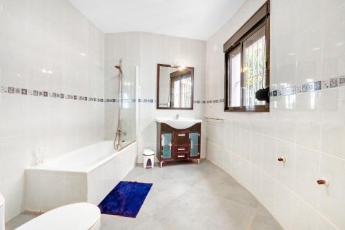 a bathroom with a tub and a toilet and a sink at Ericito in Denia