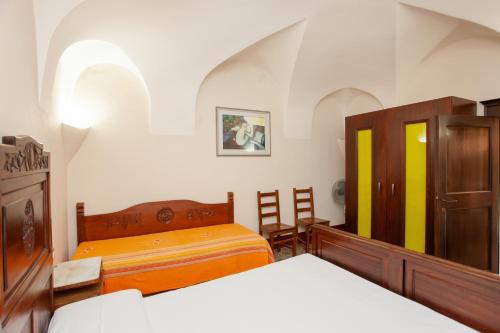 a bedroom with two beds and wooden furniture at Hora Vona in Orosei