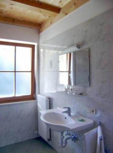 a white bathroom with a sink and a mirror at Gmosnhof Mölten in Meltina