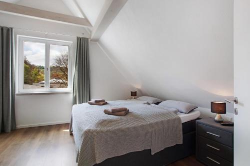 a bedroom with two beds and a window at Gut Vasbach Ferienwohnungen in Kirchhundem