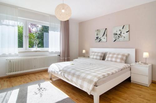 a white bedroom with a bed and a window at Ferienwohnung Am Buchbühl in Stockach