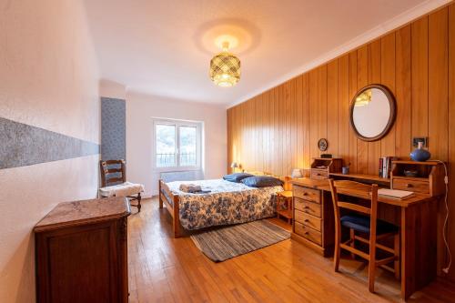una camera da letto con un letto e una scrivania di Volets Verts a Aime La Plagne