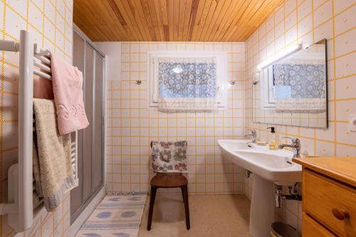 un bagno con un lavandino e una sedia di Volets Verts a Aime La Plagne