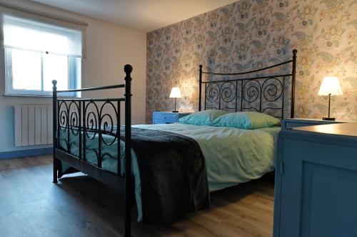 a bedroom with a black bed and a window at Chez Jeanne, charmante maison in Dossenheim-sur-Zinsel