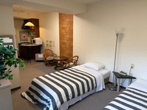a hotel room with two beds and a kitchen at フューデイズコンドミニアム定山渓101号室 in Jozankei