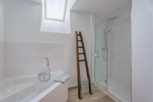 a ladder in a bathroom with a glass shower at La ferme d'Alcide in Québriac