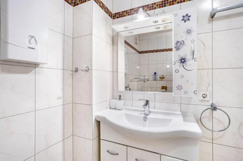 a white bathroom with a sink and a mirror at Ferienappartement Möhnesee mit Pool in Möhnesee