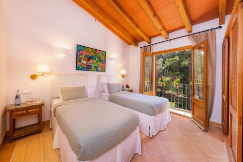 two beds in a room with a window at Can Petit Estel in Betlem