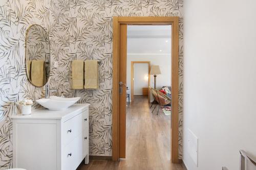 a bathroom with a sink and a mirror on a wall at Casa no Campo com vista mar in Loulé