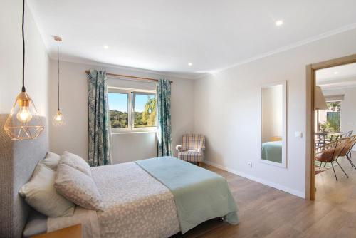 a bedroom with a bed and a table and chairs at Casa no Campo com vista mar in Loulé
