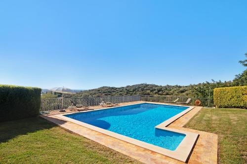a swimming pool in the backyard of a house at Casa no Campo com vista mar in Loulé