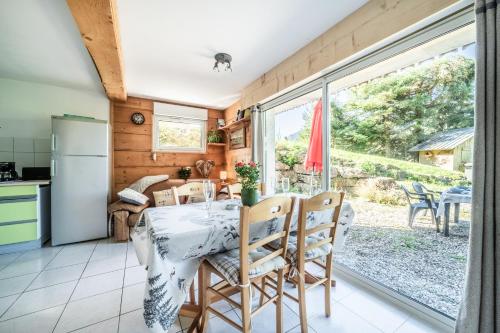 a kitchen and dining room with a table and chairs at Chalet Les Mios, chez Isa in Vacheresse