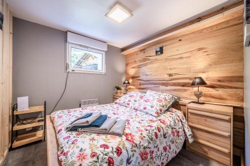 a bedroom with a bed and a wooden wall at Chalet Les Mios, chez Isa in Vacheresse