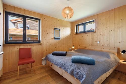a bedroom with a bed and a red chair at Ostseeseele in Parin