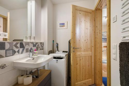 a bathroom with a sink and a wooden door at Ostseeseele in Parin