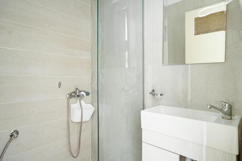 a bathroom with a white sink and a shower at Iguana studio 8 in Preveza