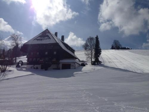 a large wooden barn with snow on the ground at Haus Winterberg in Schonach