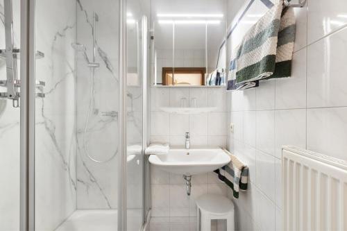 a white bathroom with a shower and a sink at Ferienwohnung Südschwarzwald in Bräunlingen