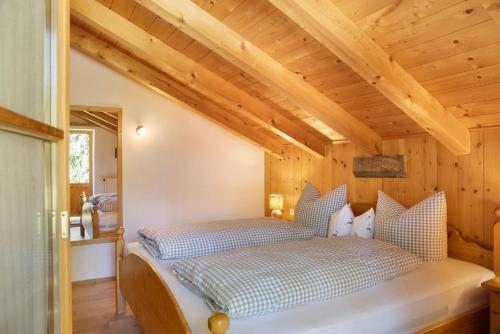 a bedroom with a bed in a room with wooden ceilings at Ferienwohnung Bergkristall in Grainau