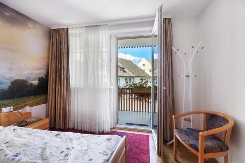 a bedroom with a bed and a door to a balcony at Ferienwohnung Südschwarzwald in Bräunlingen