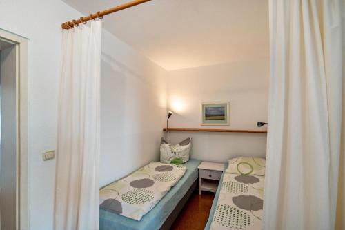 a small room with two beds and a curtain at Möve Aba Appartment 22 in Rerik