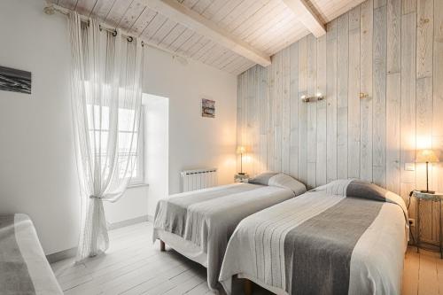 a bedroom with two beds and a window at Maison de la côte in La Flotte