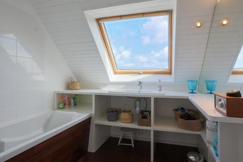 a bathroom with a tub and a sink and a window at L'hermine - Villa de charme in Locquirec