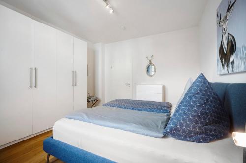 a bedroom with a white couch and blue pillows at Ferienwohnung Flür in Weiler-Simmerberg