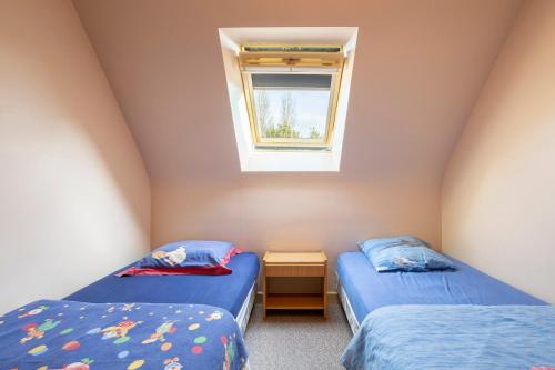 two twin beds in a room with a window at Gite Terre Mer Des Sables Blancs in Plobannalec-Lesconil