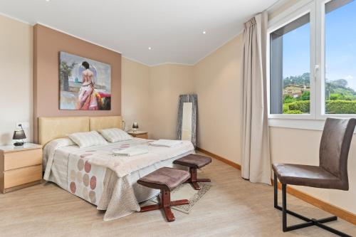 a bedroom with a bed and a chair and a window at Casa La Manzana in Villaviciosa