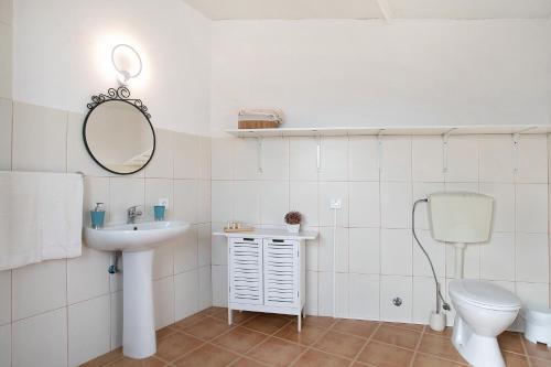 a bathroom with a sink and a toilet and a mirror at Bouros's Cliff in Serra do Bouro