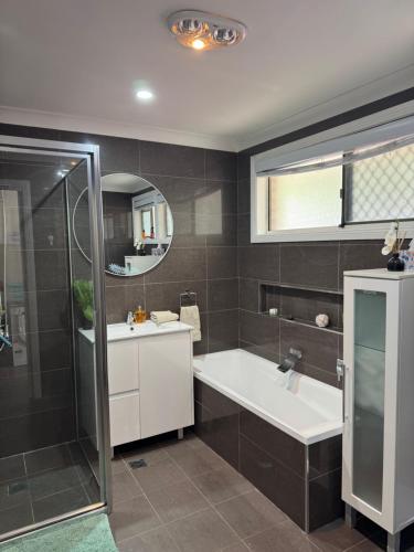a bathroom with a tub and a sink and a mirror at Garlin Corner in Leggs Island