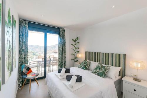 a bedroom with a large bed and a balcony at Modern Apartment in Cómpeta I in Cómpeta