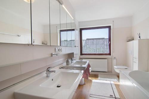 a white bathroom with a sink and a toilet at Ferienhaus Christine Bodensee Nord in Pfullendorf