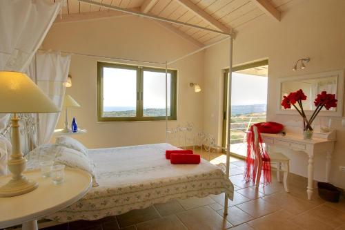 a bedroom with a bed and a table and a desk at Villa Nautilos Ideales Resort in Kefallonia