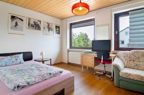 a bedroom with a bed and a desk and a chair at Ferienhaus Christine Bodensee Nord in Pfullendorf