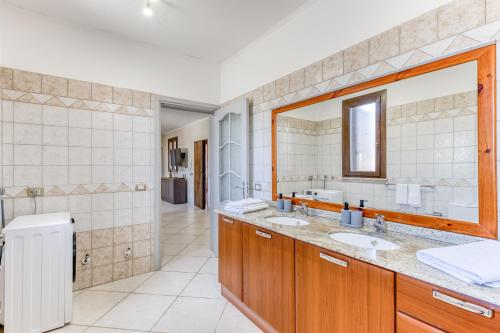 a bathroom with two sinks and a large mirror at Villa Marilor in Salve