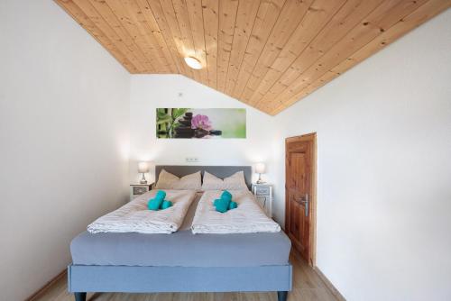 a bedroom with a bed with blue pillows on it at Martin´s Alm in Friesenried
