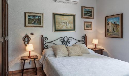 a bedroom with a large bed with two lamps at Villa Lucia in Costa Rei