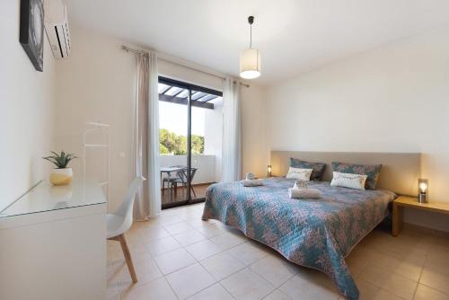 a bedroom with a bed and a desk and a window at Duo Village in Alvor