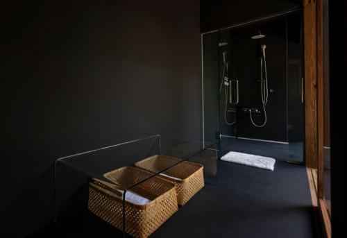 a bathroom with a glass shower with two baskets at Mifuneyama Rakuen Hotel in Takeo