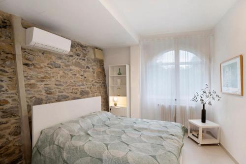 a bedroom with a bed and a stone wall at Loggia Oliveto in Casanova Lerrore