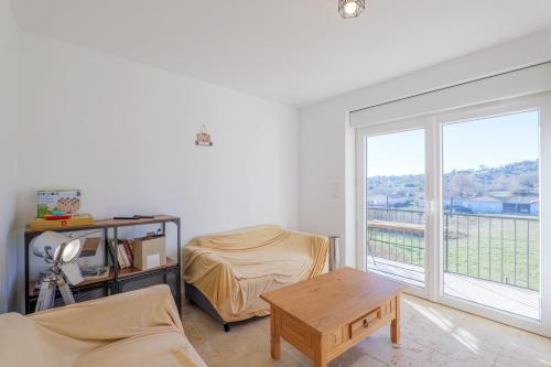 un soggiorno con un letto e una grande finestra di Mas Des Genêts a Laurac-en-Vivarais
