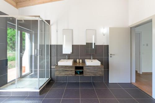 a bathroom with two sinks and a shower at Paraiso da Serva - Flor do Rosto 1 in Odemira