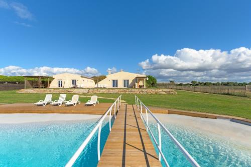a swimming pool with lounge chairs and a house at Paraiso da Serva - Flor do Rosto 1 in Odemira