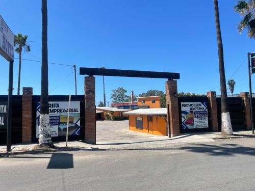 an empty parking lot with an orange building in the background at Hotel Ranchito in Ensenada