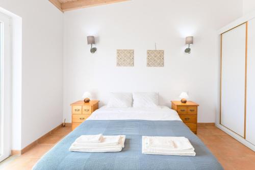 a bedroom with a bed with two towels on it at Paraiso da Serva - Flor do Rosto 1 in Odemira