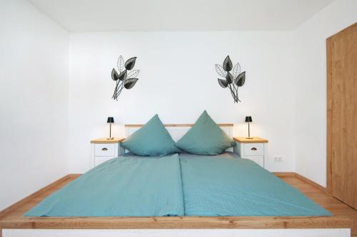 a bedroom with a bed with blue sheets and two lamps at Ferienhaus Donauliebe in Vohburg an der Donau